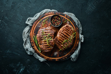 Grilled beef steak medium rare on a black stone table. Top view. Free space for your text.