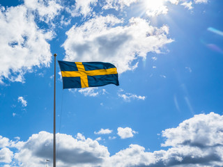 Swedish Flag on blue sky white clouds. Swedish Flag Day concept. . Sveriges nationaldag. National Day of Sweden. Swedish Flag Day. 