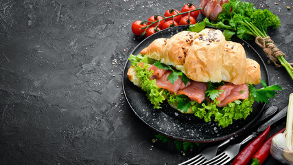 Sandwich Croissant with salmon, tomatoes and onions. Breakfast. Top view. Free space for your text.