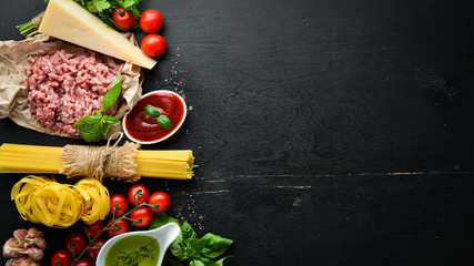 Ingredients for pasta Bolognese. On a black background. Top view. Free space for your text.