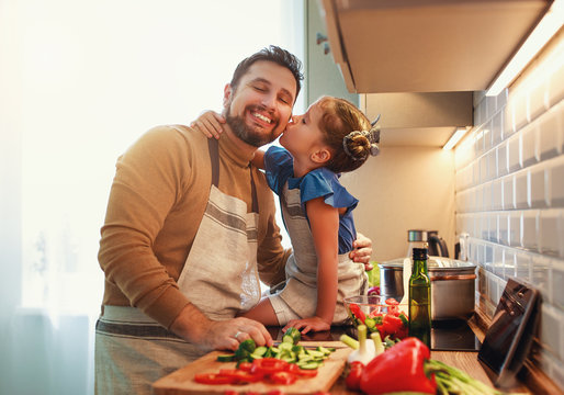 happy family father with child daughter preparing vegetable salad .