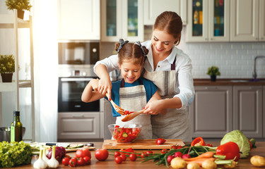 happy family mother with child girl preparing vegetable salad .