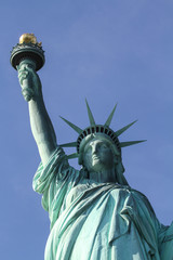 Plakat statue of liberty in new york with torch - close up with blue sky