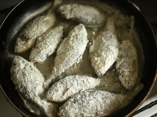 small crucian carp in flour fried in a pan