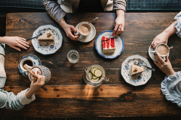 Top view of friends sitting at wooden table in a cafe