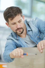man assembles furniture