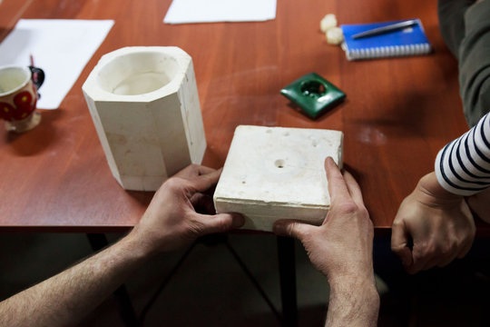 meeting potters. training courses for novice ceramists. the master potter with 15 years of experience shows a gypsum mold for making many ceramic cup and socket. reportage