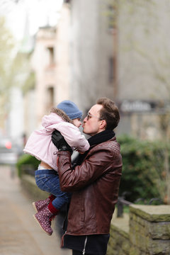 Father holding and kissing his daughter in the city