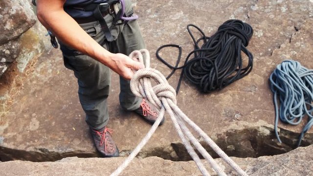 Climber makes a safety knot to climb the steep wall. Mount Wellington , Australia.