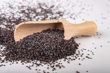 Poppy seed on the kitchen table. Spilled poppy seed and wooden spoon.