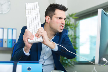 angry man is destroying a keyboard