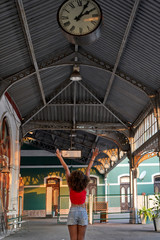 Happy woman under the clock at the train station