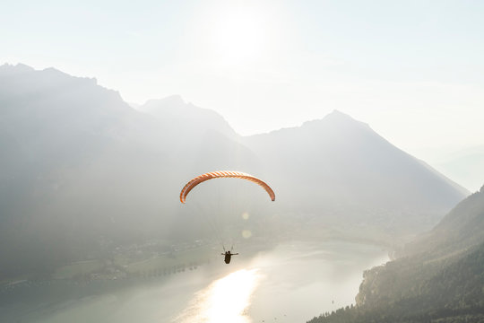 Austria, Tyrol, Paraglider over lake Achensee in the early morning