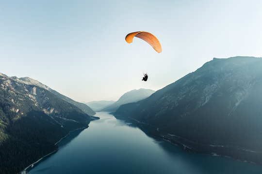 Austria, Tyrol, Paraglider over lake Achensee in the early morning