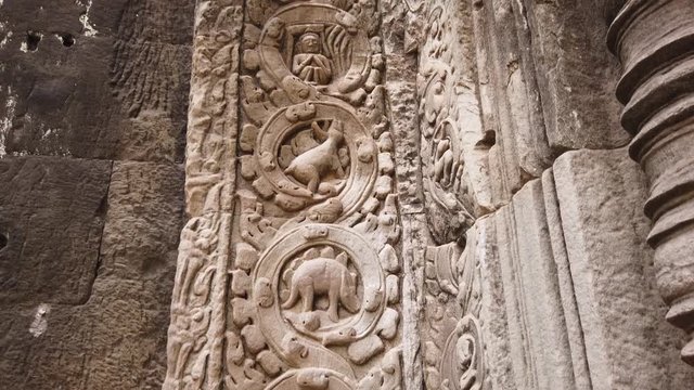 ancient bas-reliefs depicting a dinosaur in the ancient temple of TA Prohm. One of the most famous temples of Angkor, TA Prohm is known for its huge trees and roots growing from 