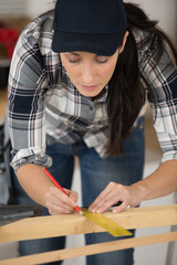 Fototapeta na wymiar woman measuring a wooden plank