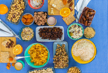 Top view of cereals, walnuts, dried plums and dates served in bowls