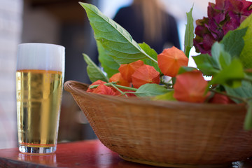 Scheidel, Luxembourg - September 8 2018 : Fresh glass of beer next to a basket with physalis fruit