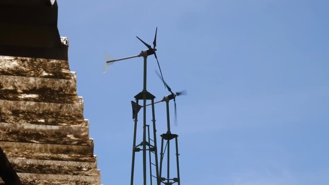 Static shot of windmills, propellers turning in the wind, at a farm, in the savannas of Masai Park, in Kenya, Africa