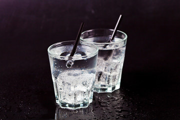 Two glasses of fresh cold carbonated water with ice cubes.