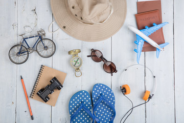 Prepare for journey - accessories and travel items, packing clothes: hat, passport, tickets, model of airplane and bicycle, flip flops, sunglasses, compass