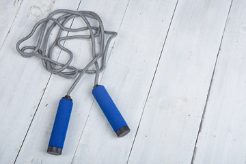 Fitness/sport and healthy lifestyle concept - Jumping/skipping rope with blue handles