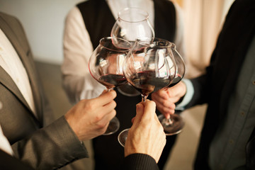 High angle closeup of people in formalwear clinking wine glasses during event, copy space