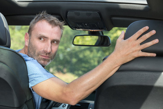 Mature Professional Man Driving A Car In Reverse