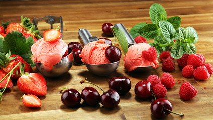 different ice cream in sundae cups and spoon with fresh berries and cherries on table