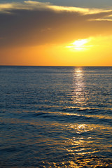 Fototapeta premium Colorful empty seascape with shiny sea over cloudy sky and sun during sunset in Cozumel, Mexico