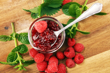 raspberry jam with fresh raspberries and mint. marmalade on spoon and jar