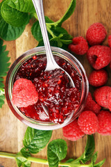 raspberry jam with fresh raspberries and mint. marmalade on spoon and jar