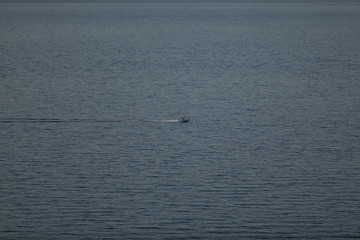 Obraz premium Small launch boat with people in the sea, 4 to 3 proportions