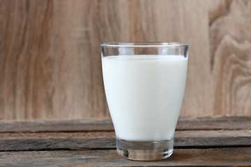 Glass of milk on wooden background