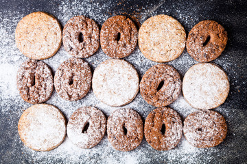 Chocolate chip and oat fresh cookies with sugar powder closeup on black background.
