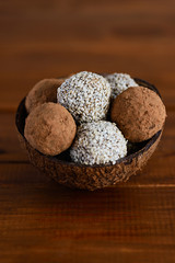 Energy balls of dates, nuts, cocoa and sesame. Raw dessert on wooden table