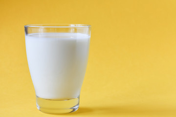 Glass of milk on yellow background