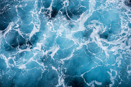 Rough deep turquoise and blue Mediterranean sea with white foam texture background