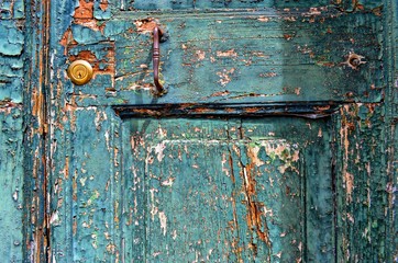 texture of a very old wooden door, in which a new lock is cut , with cracked and crumbled paint