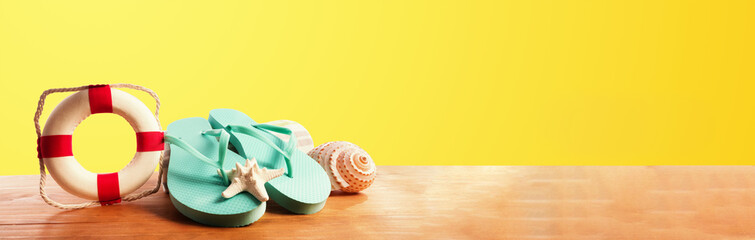 Flip flops with buoy on a yellow background