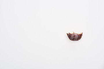 top view of bitten chocolate doughnut on white background with copy space