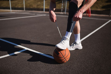 Basketball player tying basketball shoes