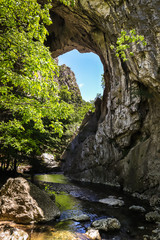 Fototapeta na wymiar Natural stone bridge in Vratna river gorge in Serbia, called Vratnjanske kapije. This arches is a largest natural bridges in Europe.