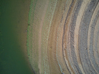 Aerial view of the Valdecañas reservoir, with green water from the algae and natural lines of the...