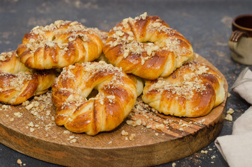 Sweet fresh baked buns with nuts on rustic wooden board 