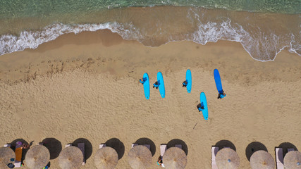 Fototapeta na wymiar Aerial drone top view photo of young team of surfers enjoying tropical wavy turquoise sea sandy beach in exotic caribbean island