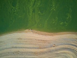 Aerial view of the Valdecañas reservoir, with green water from the algae and natural lines of the...
