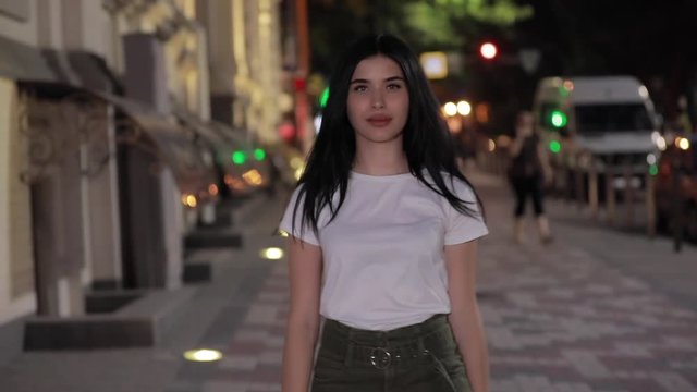 Cute woman walking in night city street