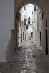 Una callejuela estrecha y pintoresca en el pueblo blanco de Ostuni, en la región de Puglia, Italia