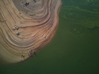 Aerial view of fishermen in the swamp of Valdecañas, with green water by algae and natural lines...